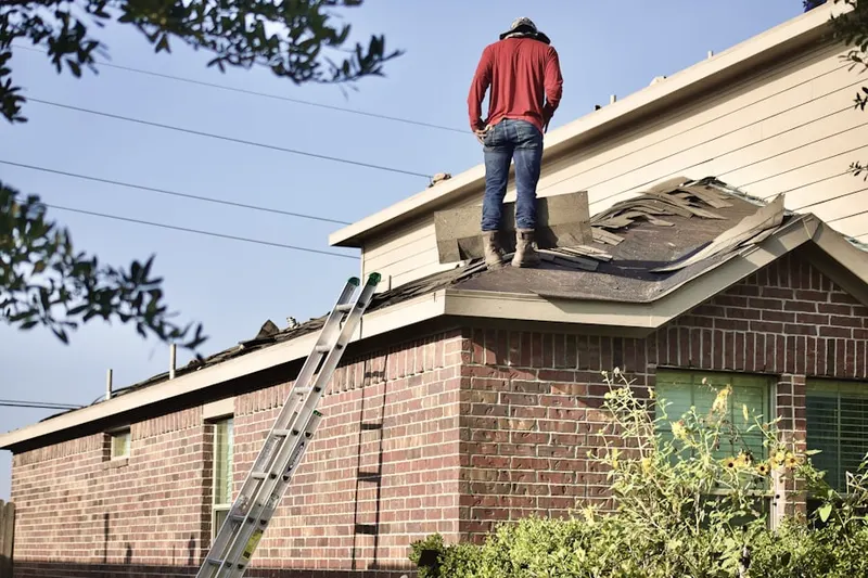 Professional roofer working on a residential roof in Perinton